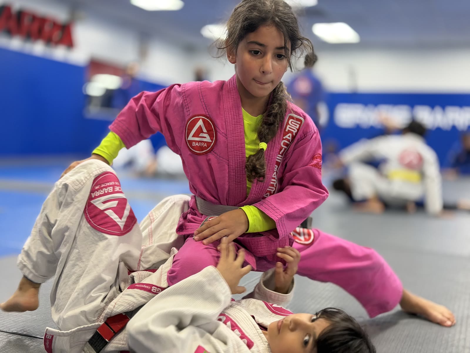 Champs 2 Jiu-Jitsu Partner Practice – Gracie Barra Westchase Champs 2 students in pink and white gis practicing ground control at Gracie Barra Westchase in Houston