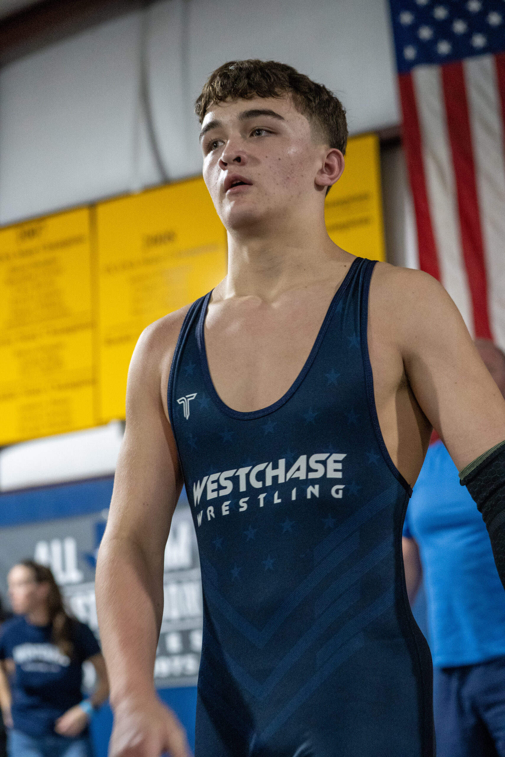 Wrestler wearing a navy Westchase Wrestling singlet at a competition.
