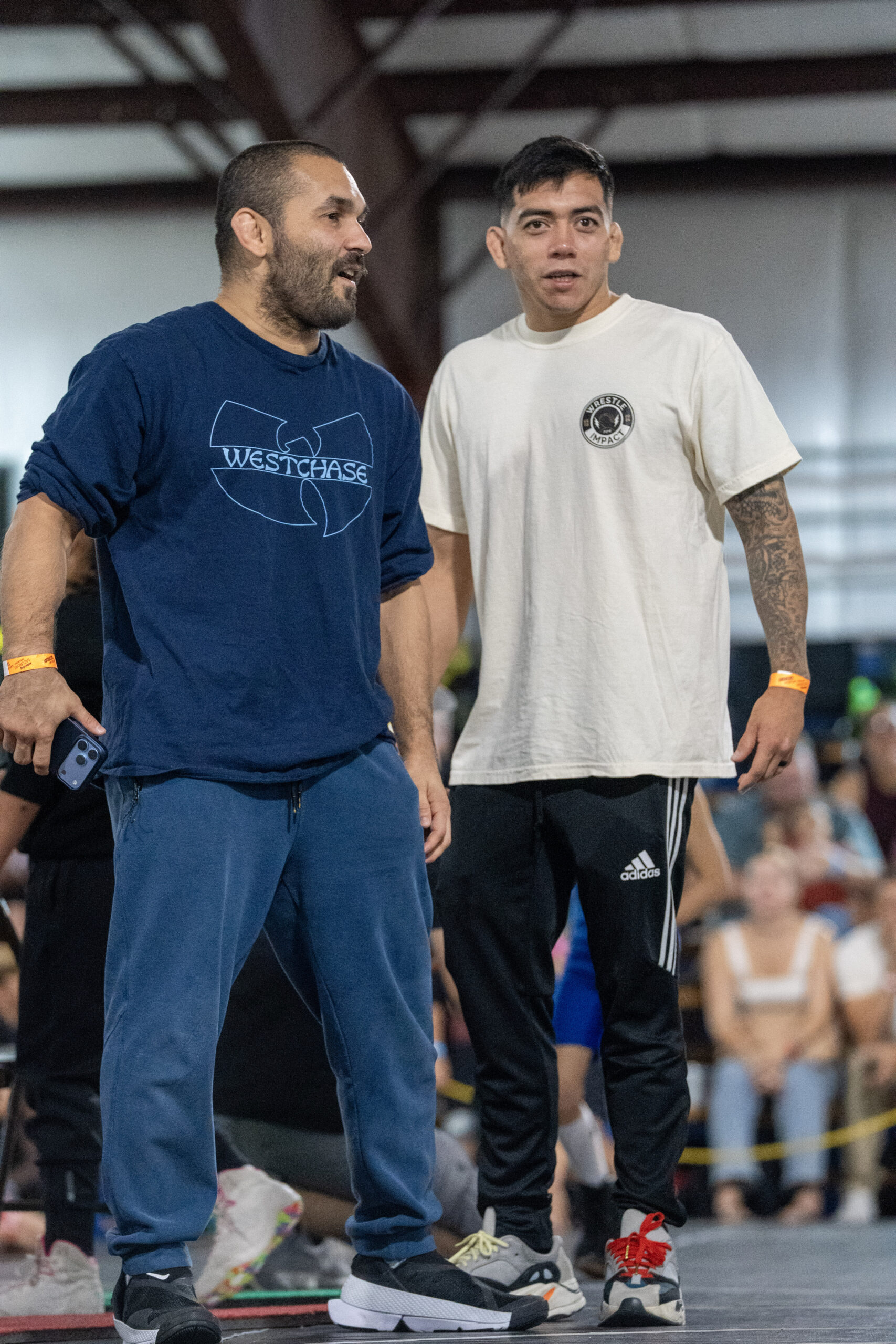 Two Westchase Wrestling team members standing beside the competition mat.
