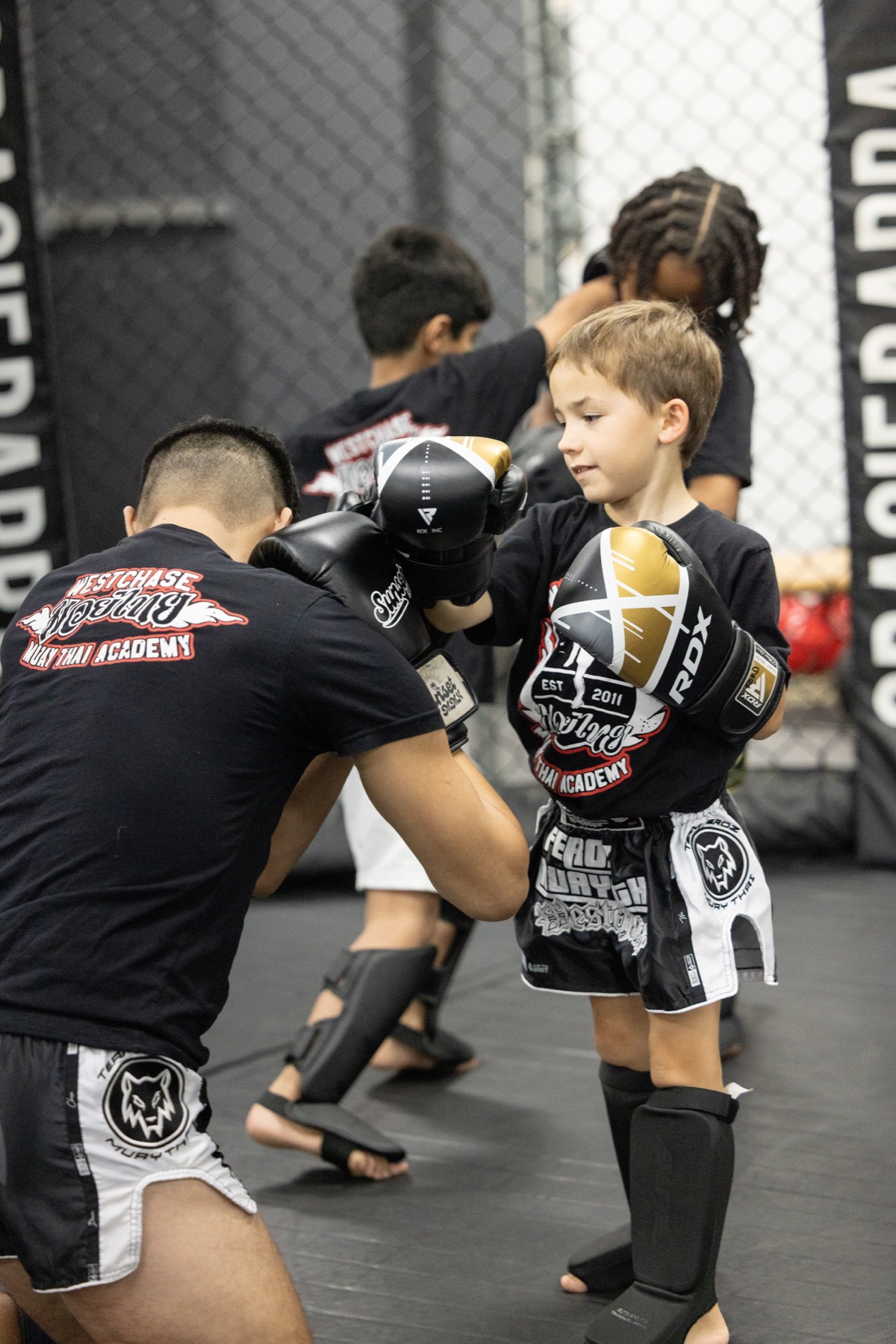 Children practicing kickboxing partner drills at Gracie Barra Westchase in Houston
